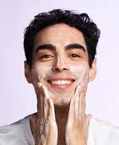 Bild på en man som rengör ansiktet med Deep Clean AHA Cleanser