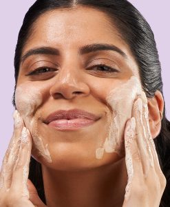 Kvinna rengör ansiktet med 3-in-1 Clarifying Cleanser